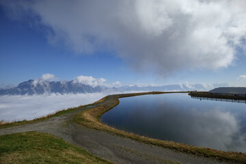 Stunning alpine landscape in Saalbach Hinterglemm with a serene lake and dramatic mountain backdrop...