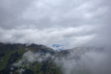 Mountainous landscape in Austria enveloped by mist and clouds creating a serene, atmospheric view of nature