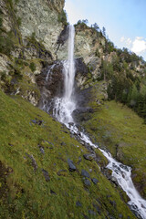 Spectacular waterfall cascading down rocky cliffs in Grossglockner region of Austria