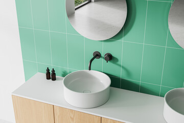 Minimalist bathroom vanity with round white sink, matte black faucet, and green tiled wall. 3D Rendering