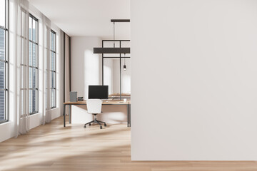 Modern office interior with open space and wooden flooring, featuring a desk and chair near large...