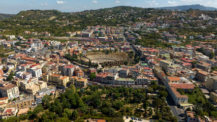 Aerial view of the Flavian Amphitheater, located in the historic center of Pozzuoli, near Naples, Italy. In the background is the train station. 