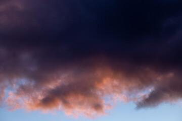 Obraz premium Dark clouds are covering the orange sunset sky