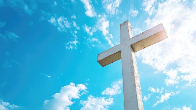 White wooden cross against a bright blue sky symbolizing faith and spirituality in a serene outdoor setting. - Powered by Adobe