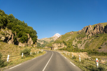 Naklejka premium A road with a mountain in the background. The road is empty and the sky is clear