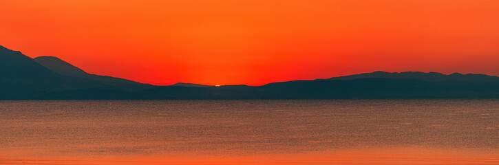 Fototapeta premium Beautiful dawn at Aegean sea, vibrant orange sky moments before the sunrise seen from Vrasna in Greece