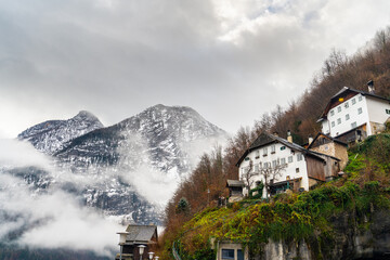 Wooden houses built on a hillside, typical of Hallstatt architecture, often have colorful facades...