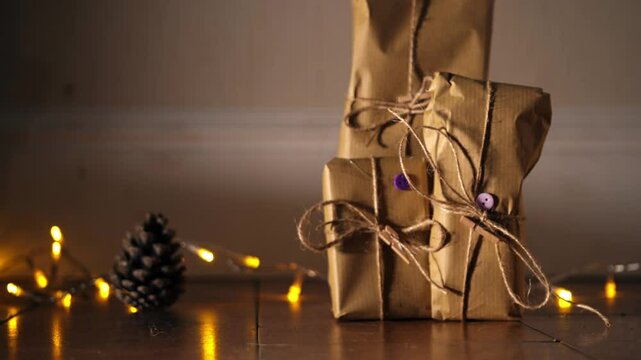 Gift wrapped in brown paper and string with Christmas lights bokeh background