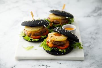 Black burgers with grilled pineapple