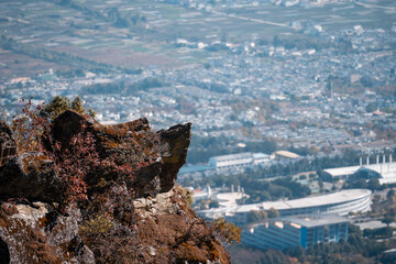 Panoramic view from a rocky outcrop in Yunnan, China, overlooking a sprawling Dali city and its...