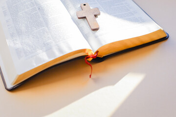 holy bible and cross on the table on pastel background.