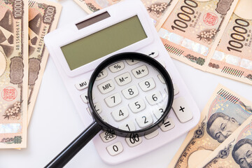 電卓と虫眼鏡とお金