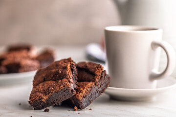 Homemade chocolate brownies and coffee cup on kitchen table.