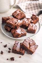 Homemade chocolate brownies on plate on kitchen table.