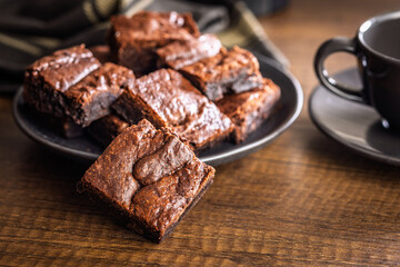 Homemade chocolate brownies on plate on wooden table.