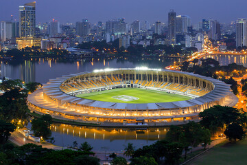 Fototapeta premium night stadium aerial view, field markings crisp under lights, surrounding city darkness