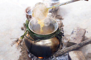 celebrating Traditional Thai Pongal festival to sun god with pot, lamp,wood fire stove, fruits and sugarcane. Making Sakkarai or sugar pongal and ven pongal in sand stove in traditional method.