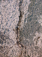 A close-up of a cracked surface with peeling white paint and exposed green beneath, showcasing rough textures and imperfections. Suitable for grunge backgrounds or design references