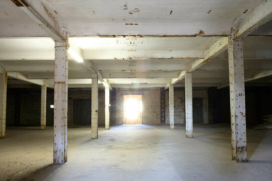 Abandoned industrial warehouse interior with sunlight streaming through an open door, Berlin, Germany