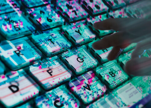 Hands typing at laptop with the computer hardware revealed underneath, symbolic for AI technology landscape