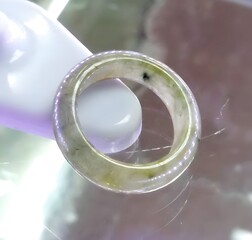 Elegant Green Jade Ring on Display with Reflections and Highlights