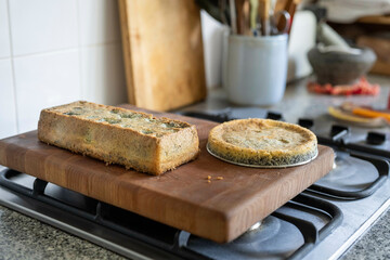 Sliced bread with and cake is placed on a wooden cutting board on a kitchen stove