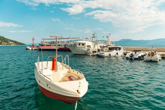 A fleet of boats moored at a sunny seaside harbor with clear blue skies in the background, , Drvenik, Croatia.