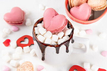Valentine`s day hot chocolate or latte mug with heart shaped marshmallow and macaron cookie