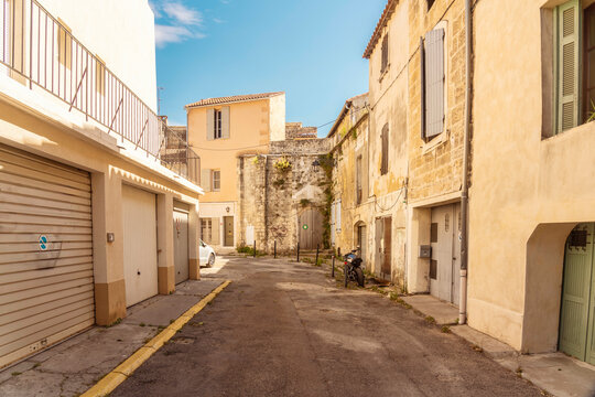Fototapeta Narrow street with colorful shutters and historic buildings in Arles, France