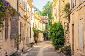 Narrow street with colorful shutters and historic buildings in Arles, France