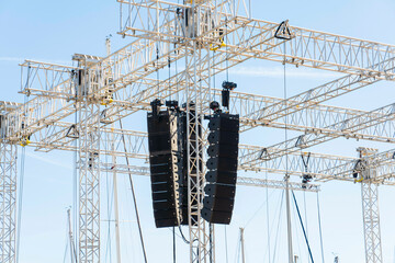 Array of professional line array speakers suspended from a metal truss at an outdoor event, Marseille, France