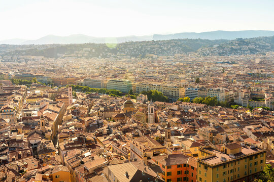 Aerial view of a sprawling cityscape basking in the golden light of the sun with clear skies and dense building clusters in Nice, France