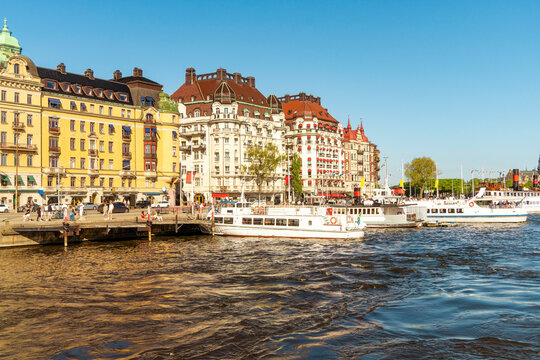 Stockholm waterfront with elegant buildings and tour boats under a clear blue sky by Ostermalm, Stockholm, Sweden