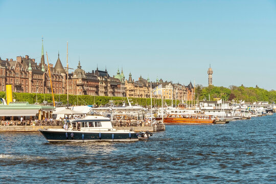 Busy waterfront with boats and crowd enjoying a sunny day in a picturesque city setting in Stockholm Ostermalm, Sweden