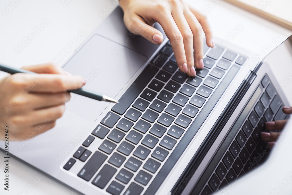 Poster a close view of a woman's hands typing on a modern laptop keyboard, office surroundings appearing fu