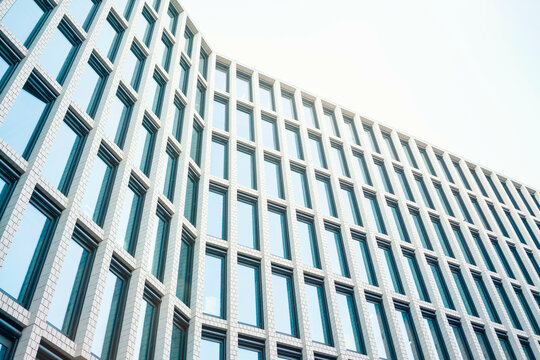 Modern architectural facade of a high-rise building with repeating patterns of windows and a clear blue sky in the background, Berlin, Germany