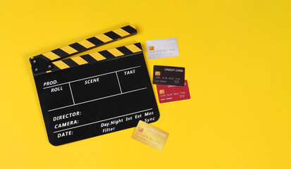 clapper board and credit cars on yellow background