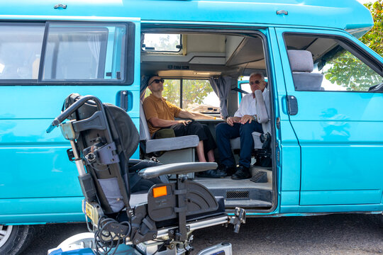 Two men discussing inside a Van equipped for Wheelchair access
