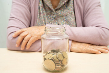 Retired Asian elderly woman counting coins money and worry about monthly expenses and treatment fee...