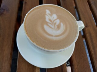 cup of coffee with a leaf design on the foam