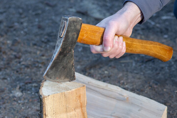 A lumberjack chops wood with an axe. A tool designed for chopping and hewing. Harvesting wood.
