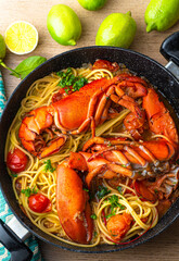 Lobster linguine pasta served with tomatoes and fresh lemons. Delicatessen, rare seafood pasta recipe. Sardinia, Sicilian, Neapolitan cuisine. Italian and French, Nord America  recipe. Top view
