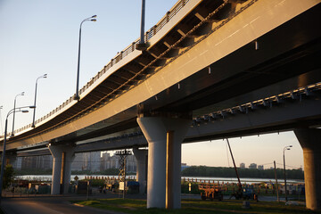 Fototapeta premium bottom view of a large automobile bridge with lanterns over the river