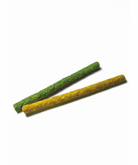 Assorted pet chews and treats on a white background. Different colors and textures show the natural look of dog food.