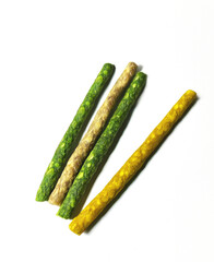 Assorted pet chews and treats on a white background. Different colors and textures show the natural look of dog food. 