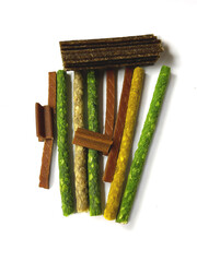 Assorted pet chews and treats on a white background. Different colors and textures show the natural look of dog food. 