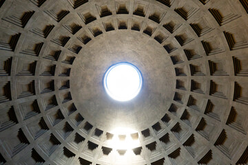 Interior view of Pantheon dome oculus in Rome on a sunny day with sun shining through the hole in...