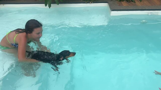 menina com cachorro nadando em piscina 