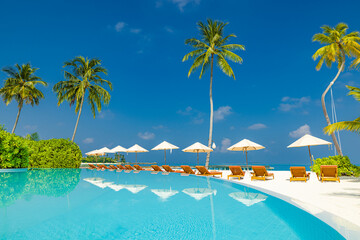 Amazing landscape, swimming pool blue sky with clouds. Tropical resort hotel in Maldives. Fantastic relaxing peaceful vibes, chairs, bed under umbrellas and palm tree leaves. Luxury vacation tourism