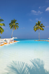 Naklejka premium Amazing landscape, swimming pool blue sky with clouds. Tropical resort hotel in Maldives. Fantastic relaxing peaceful vibes, chairs, bed under umbrellas and palm tree leaves. Luxury vacation tourism